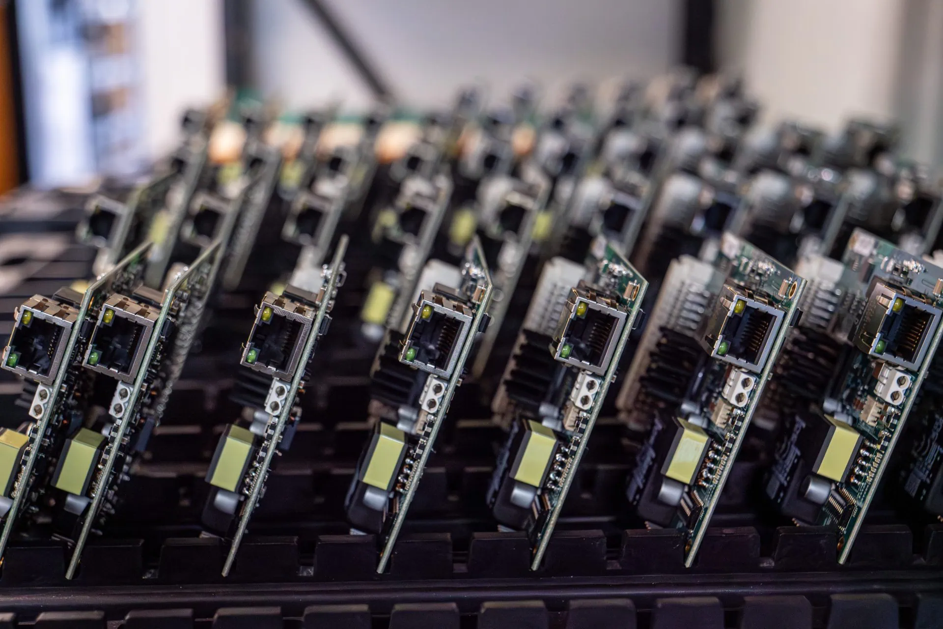 Rows of computer circuit boards with visible ethernet ports and components are arranged upright on a tray.